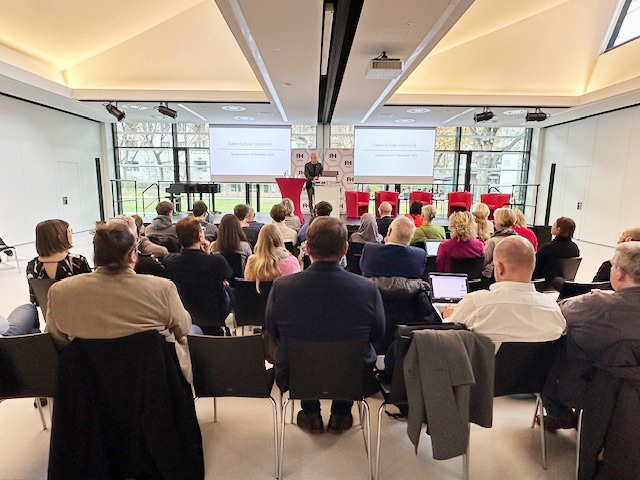 Das Foto zeigt den Veranstaltungsraum und das Publikum des Symposiums.