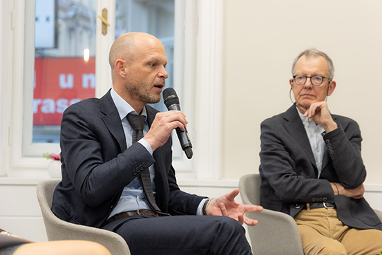 Das Foto zeigt eine Podiumsdiskussion mit IQS-Direktor Robert Klinglmair und Univ.-Prof. Mag. Dr. Michael Schratz.