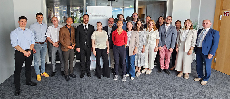 Gruppenfoto von Bundesminister Wiederkehr mit Mitarbeiterinnen und Mitarbeitern des IQS.